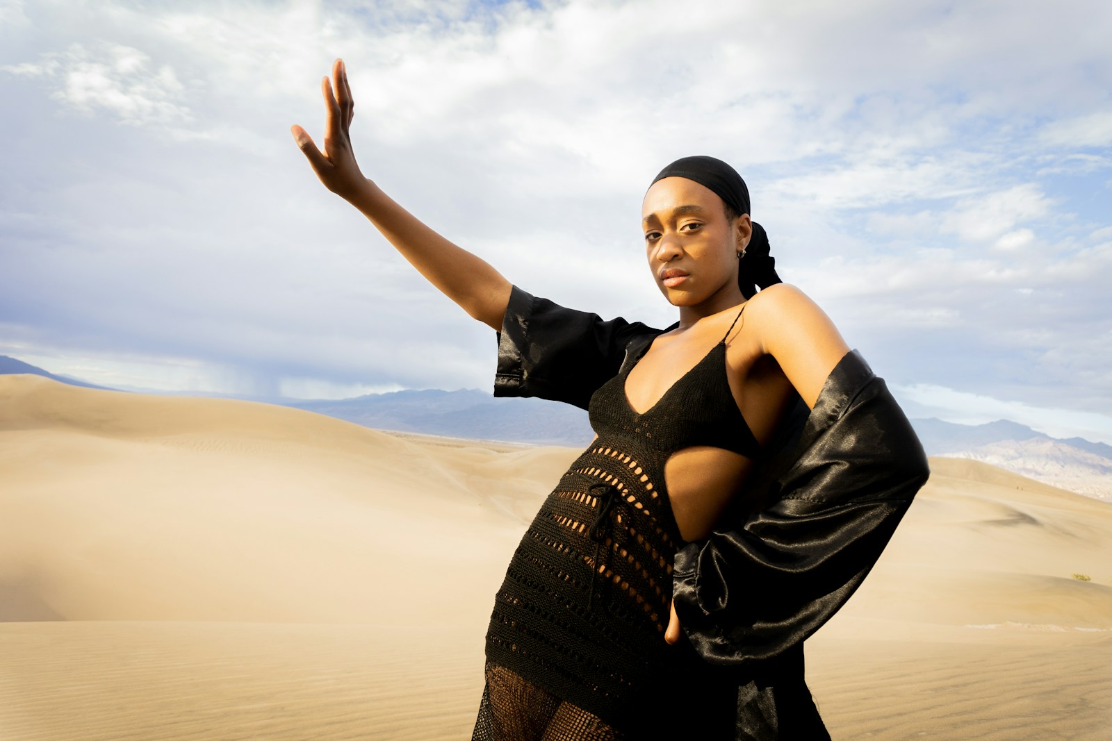 a woman in a black dress standing in the desert